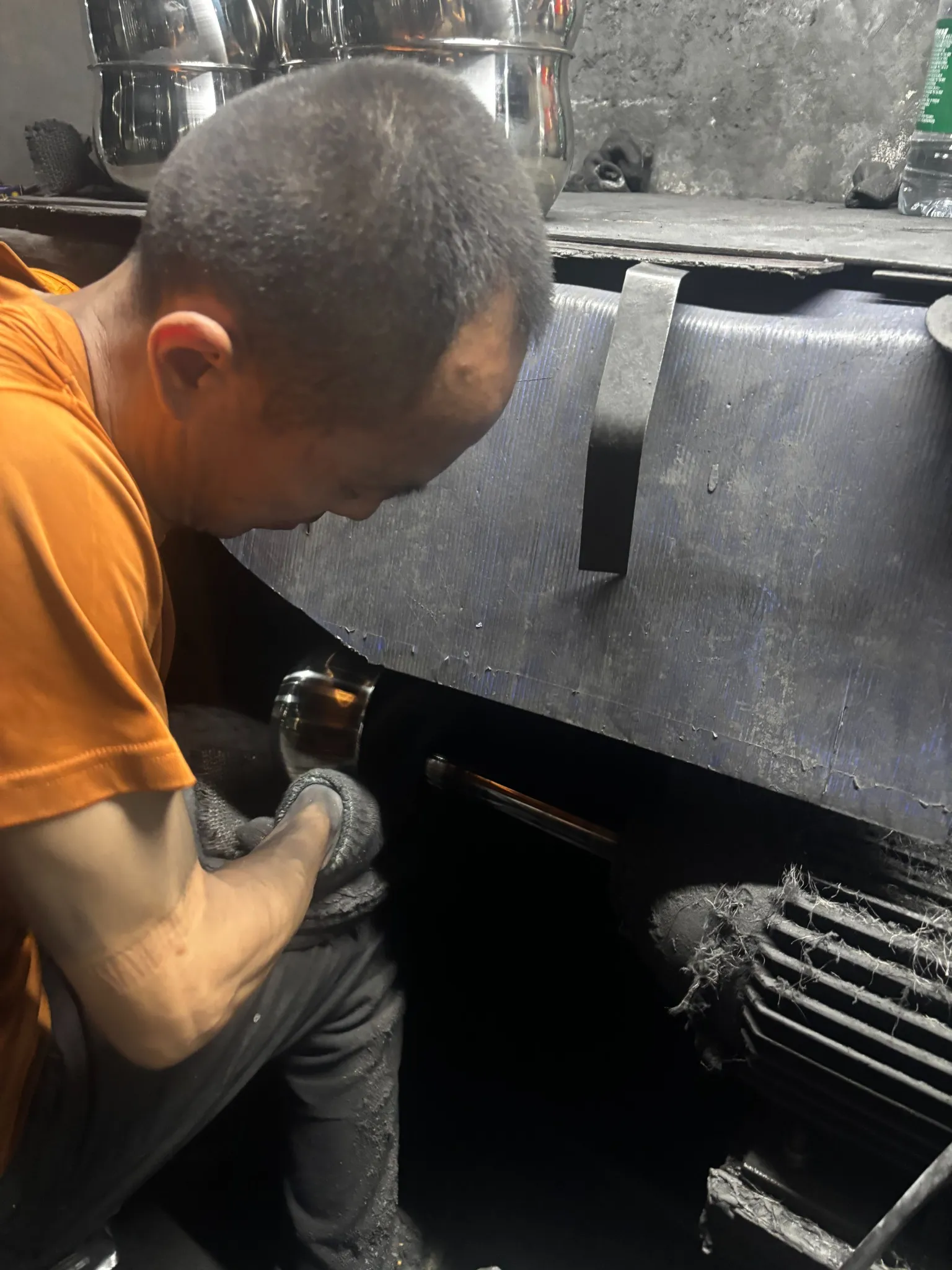 Worker polishing a stainless steel cookware body