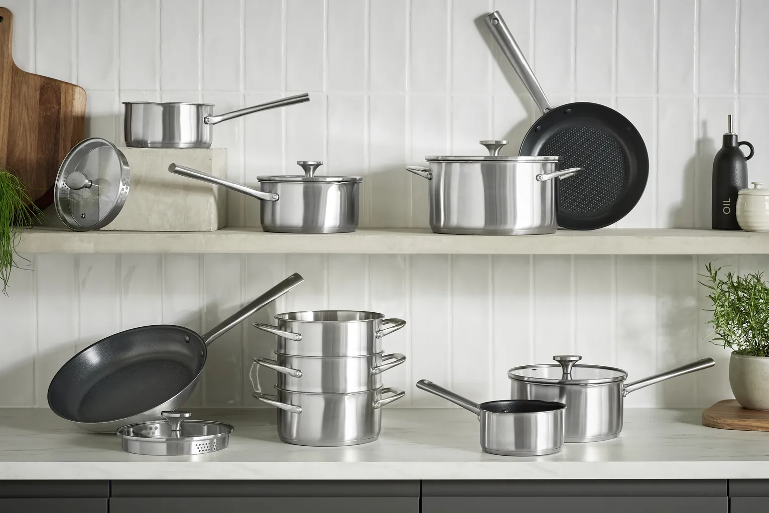 Stainless steel cookware collection displayed on kitchen shelves